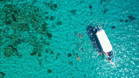 Aerial Drone Shot of Boat with Snorkelers out on the coral reef in Menjangan island, Bali, Indonesiaの写真素材