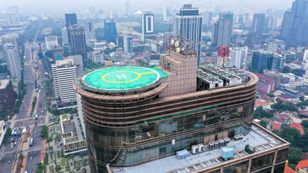 Aerial drone view of helipad on the roof of a skyscraper iin downtown with cityscape view on sunny dayの写真素材