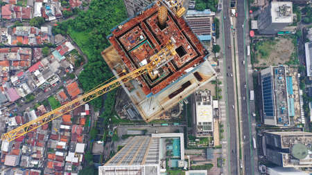 Cranes on the top of the buildings which are still under constructionの写真素材