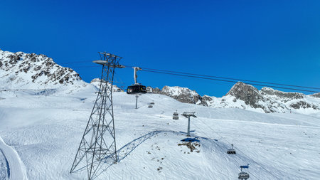 A cable car gondola descends from Piz Nair past an alpine ridge into a valley above St, Moritz.の写真素材