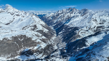 Snowy mountain valley and township. Aerial drone shotの写真素材