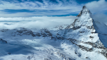 Scenic view of snowcapped Matterhorn mountain peak. Beautiful snow covered white landscape against sky. Alpine region during winterの写真素材