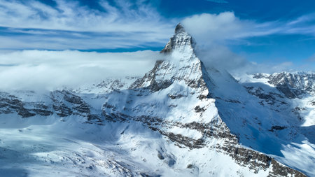 Scenic view of snowcapped Matterhorn mountain peak. Beautiful snow covered white landscape against sky. Alpine region during winterの写真素材