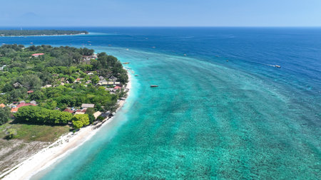 A aerial of a coral cay island surrounded by shallow reef and deep blue waterの写真素材