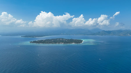 Aerial drone view of Gili Air island with clouds in the background over Lombok island. Scenic view from Gili Air overlooking Lombok misty mountains and calm seaの写真素材