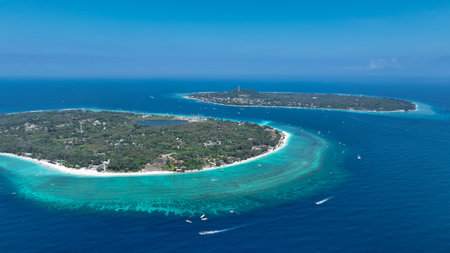 Aerial view of a small boat passing a tropical island Gili Meno in a blue oceanの写真素材