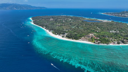 A aerial of a coral cay island surrounded by shallow reef and deep blue waterの写真素材