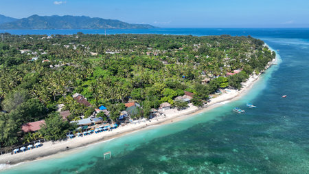 The idyllic coastline of Gili Air features turquoise waters, white sandy beaches, and charming beachfront huts, offering a serene escape in a tropical island settingの写真素材