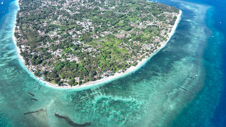 Gili Air shines in this captivating aerial shot, highlighting its lush landscape, white beaches, and surrounding coral reefs. Experience the tranquil island life and stunning natural sceneryの写真素材