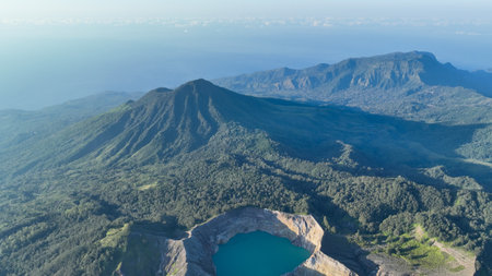 Mount Kelimutu rises dramatically above the forest canopy, guarding the legendary lakes below and capturing the wild heart of Floresの写真素材