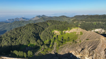 Close up nature artistry blends green forest and rugged crater edge of Kelimutu, displaying vivid...