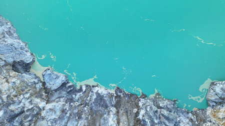 Close up of the crater edge reveals striking contrast between vivid turquoise water and rugged...