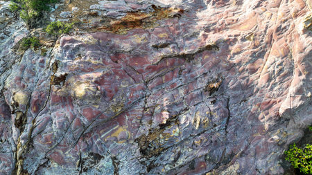 Marbled face of Strawberry Rock glowing in soft Komodo afternoon light