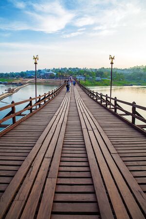 SANGKLABURI ,THAILAND - NOVEMBER 21, 2014 : Traveler crossing wooden bridge or Mon Bridge in Sangklaburi. Kanchanaburi, Thailand. Attractions traditional way of lifeの写真素材
