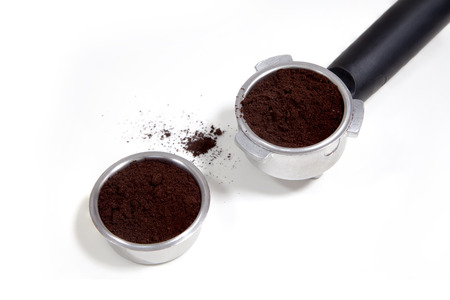 Portafilter filled with ground coffee on a white backgroundの写真素材