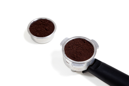 Portafilter filled with ground coffee on a white backgroundの写真素材