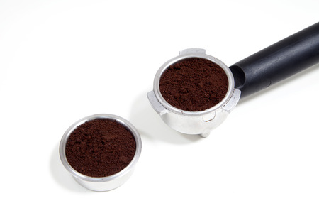 Portafilter filled with ground coffee on a white backgroundの写真素材
