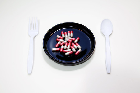 Drug use than is necessary, Drug overdose,  On black plate with fork and spoonの写真素材