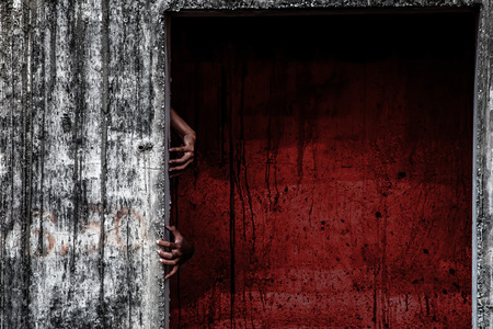 scary abandoned building with blood wall and ghost hand coming out of a doorの写真素材