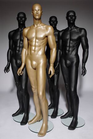 four mannequins standing alone on grey backgroundの写真素材