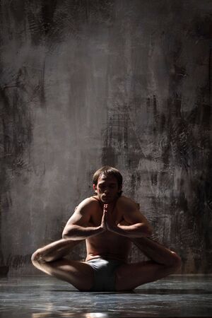 cool yoga man posing on dirty grunge backgroundの写真素材