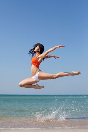 beautiful dancer posing on the sandy sea beachの写真素材