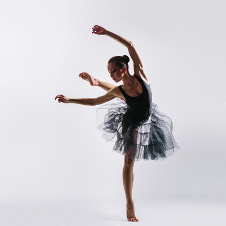 young beautiful dancer posing on studio background