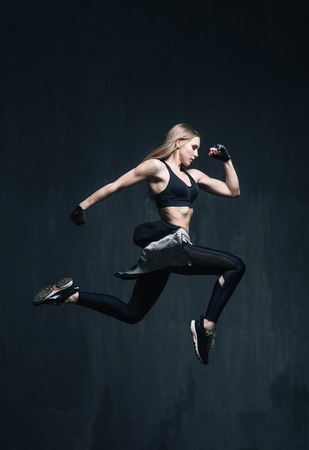 Young beautiful fitness female posing in studioの写真素材