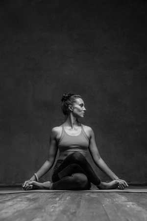 Young beautiful yoga female posing in studioの写真素材