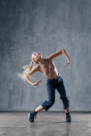 Young beautiful female dancer is posing in the studioの写真素材