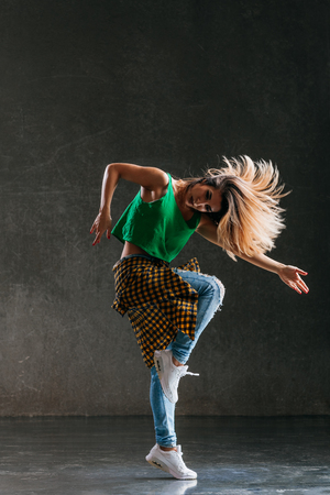 Young beautiful female dancer is posing in the studioの写真素材