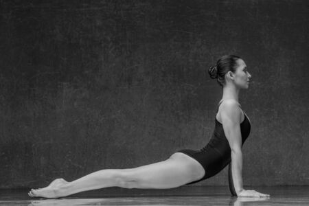 Young yoga woman stretching and training in class