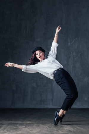 Young beautiful female dancer is posing in the studioの写真素材