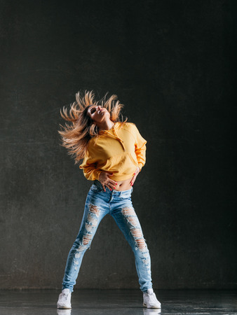 Young beautiful female dancer is posing in the studioの写真素材