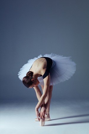 Young beautiful ballerina is posing in studioの写真素材