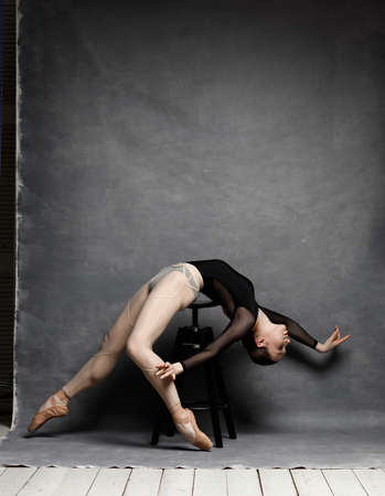 Young beautiful ballet dancer is posing in studio