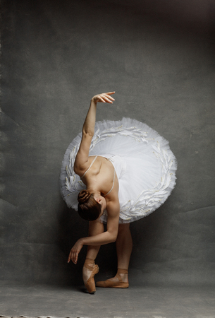 Young beautiful ballet dancer is posing in studioの写真素材