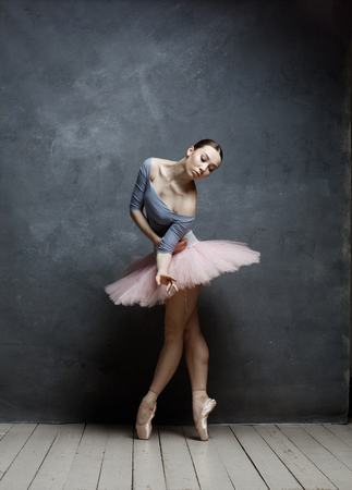 Young beautiful ballerina is posing in studioの写真素材