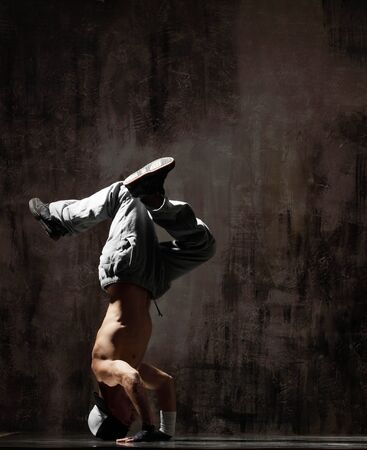 cool looking dancer posing on a grunge backgroundの写真素材