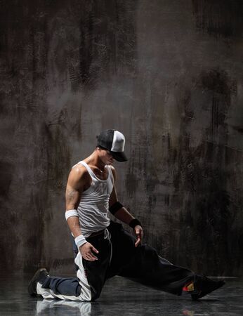 cool looking dancer posing on a grunge backgroundの写真素材