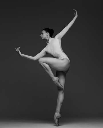 Young beautiful skinny ballerina is posing in studioの写真素材