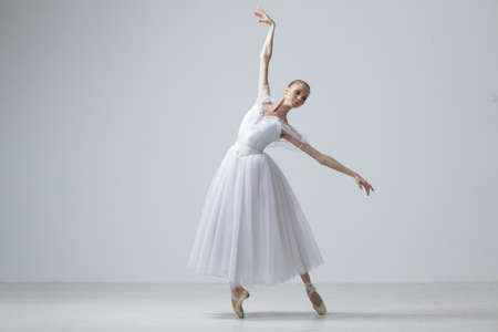 Young Beautiful Ballet Dancer Positioning on Studio Backgroundの写真素材