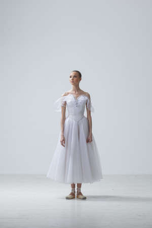 Young Beautiful Ballet Dancer Positioning on Studio Backgroundの写真素材