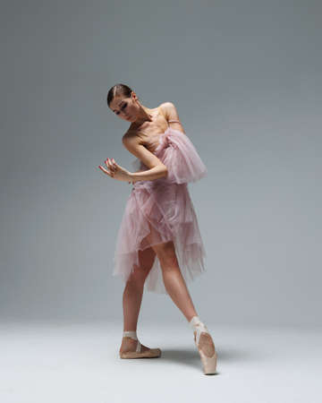 Elegant ballerina. A young graceful ballet dancer, dressed in pointes shoes demonstrates her dance skills. Power and refinement of classical ballet.の写真素材