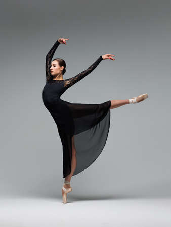 Elegant ballerina. A young graceful ballet dancer, dressed in pointes shoes demonstrates her dance skills. Power and refinement of classical ballet.の写真素材