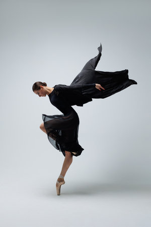 Elegant ballerina. A young graceful ballet dancer, dressed in pointes shoes demonstrates her dance skills. Power and refinement of classical ballet.の写真素材