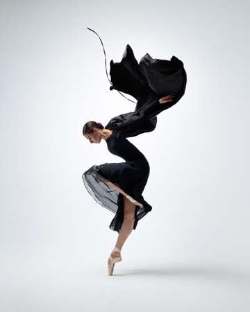 Elegant ballerina. A young graceful ballet dancer, dressed in pointes shoes demonstrates her dance skills. Power and refinement of classical ballet.の写真素材