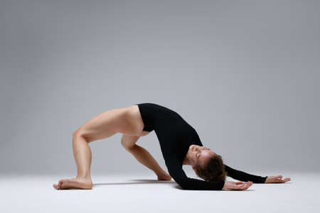 Young beautiful yoga female is exercising in studioの写真素材