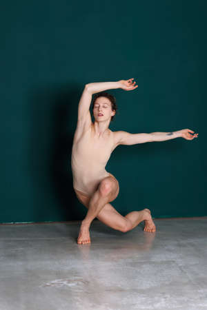 Young beautiful yoga female is exercising in studioの写真素材