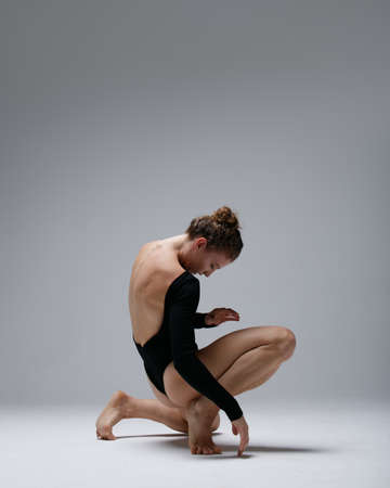 Young beautiful yoga female is exercising in studioの写真素材